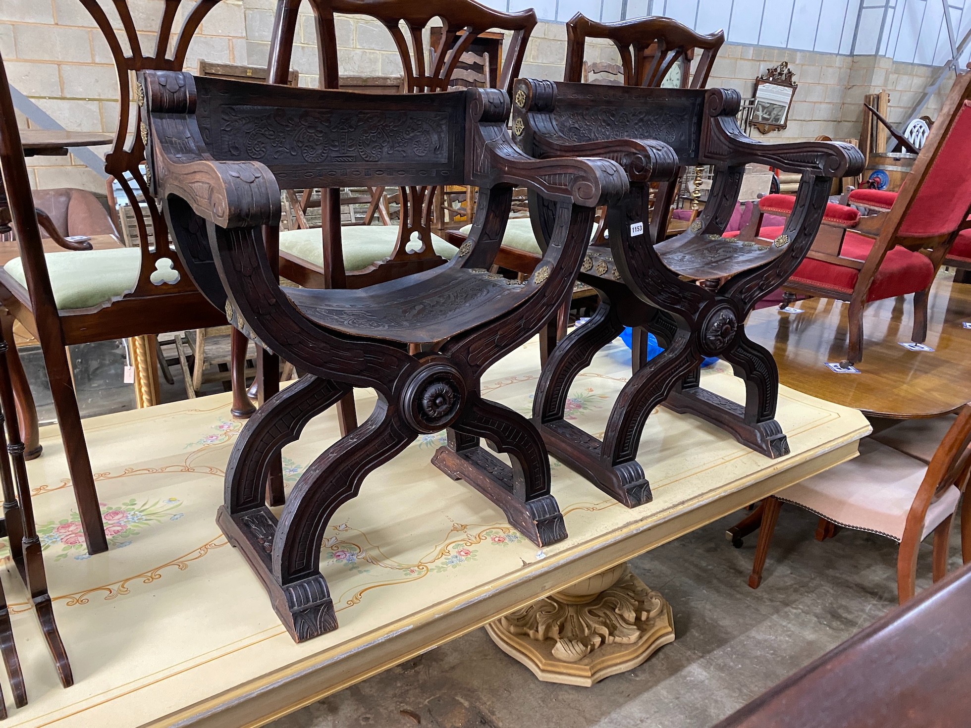 A pair of 19th century Spanish embossed leather and carved walnut framed 'X' framed armchairs, width 68cm, depth 42cm, height 76cm